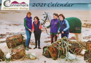 Calendar front cover, 2 children, 2 adults and a pony on a beach